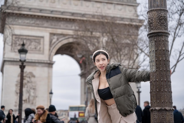 Woman tourist on background of famous Arc de Triomphe Winter or autumn in Europe Paris France