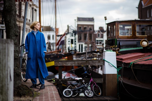 Woman tourist in the bay with ships in the Netherlands Cityscape of Rotterdam Travel and adventure