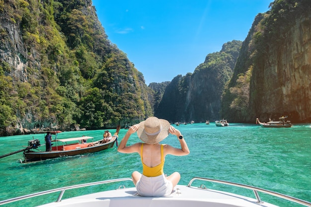 Woman tourist on boat trip happy traveller relaxing at Pileh lagoon on Phi Phi island Krabi Thailand Exotic landmark destination Southeast Asia Travel vacation and holiday concept