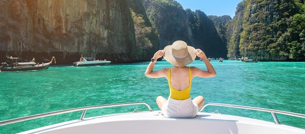 Woman tourist on boat trip happy traveller relaxing at Pileh lagoon on Phi Phi island Krabi Thailand Exotic landmark destination Southeast Asia Travel vacation and holiday concept