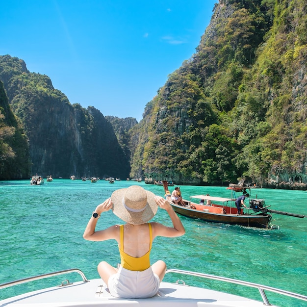 Woman tourist on boat trip happy traveller relaxing at Pileh lagoon on Phi Phi island Krabi Thailand Exotic landmark destination Southeast Asia Travel vacation and holiday concept