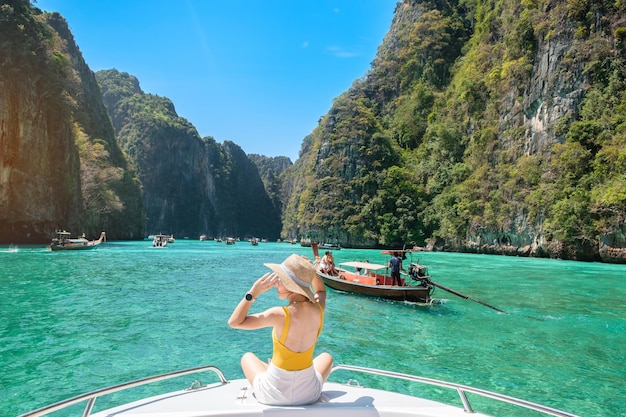 Woman tourist on boat trip happy traveller relaxing at Pileh lagoon on Phi Phi island Krabi Thailand Exotic landmark destination Southeast Asia Travel vacation and holiday concept