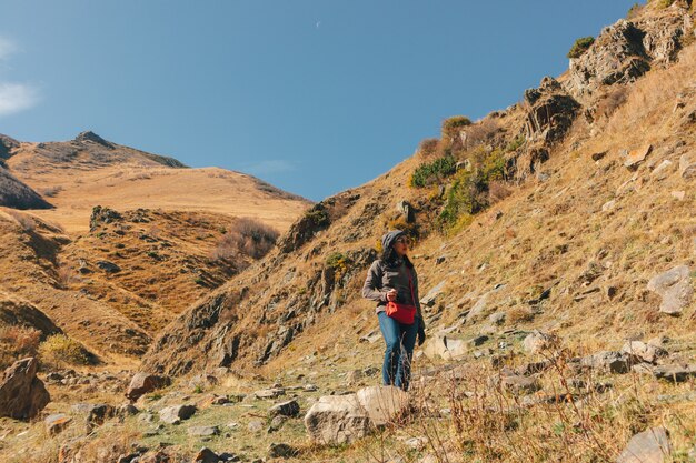 Woman tourist hiker travel through mountains trails.