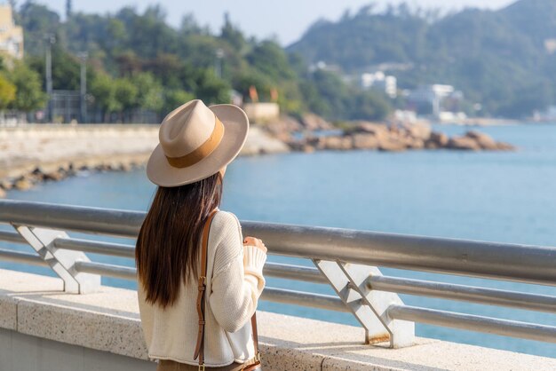 Photo woman tourist look at the sea and enjoy scenery view