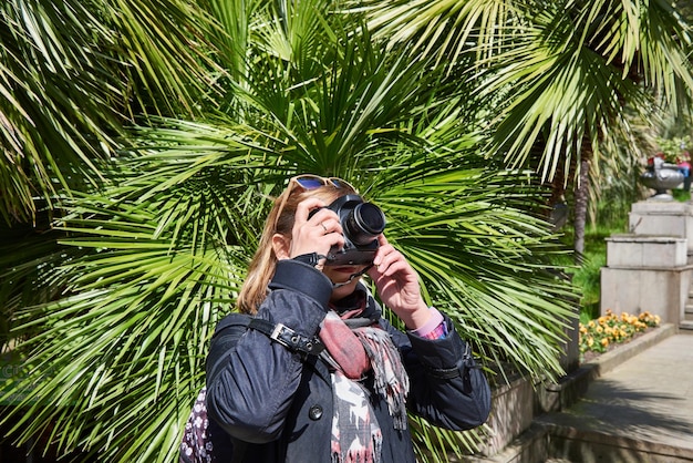 女性観光客が公園のアトラクションを撮影