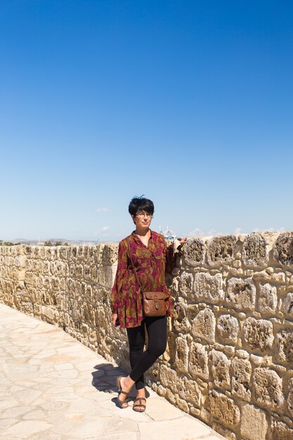 Туристическая женщина позирует возле средневекового замка.