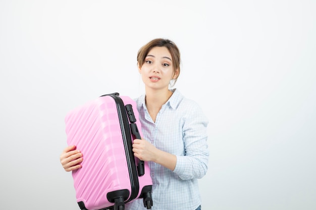 사진 핑크색 여행 가방을 들고 서 있는 여성 관광객. 고품질 사진