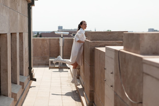 Woman tourist standing on tower terrace enjoying seeing landscape of metropolitan city