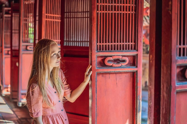 Foto turista donna nel tempio della letteratura di hanoi, nel sud-est asiatico vietnam il tempio di confucio nella capitale vietnamita è riaperto dopo la quarantena per il coronavirus covid-19