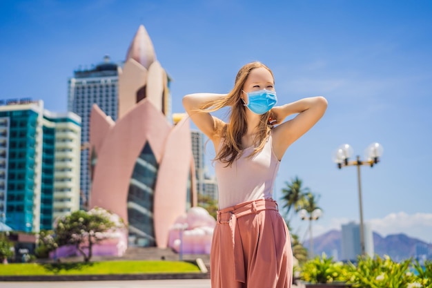 Woman tourist in vietnam nha trang put on a medical mask to protect herself from coronovirus