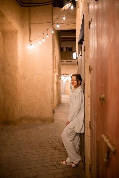 전통적인 아랍 건축물이 있는 알 시프 메라아스 두바이(Al Seef Meraas Dubai) 옛 역사 지구를 걷는 여성 관광객