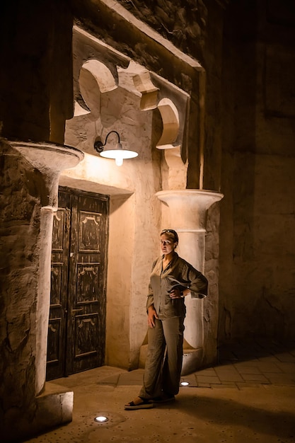 Туристка-женщина гуляет по старому историческому району Аль-Сеф Мераас Дубай с традиционной арабской архитектурой