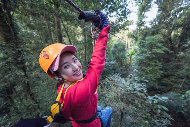 Woman Tourist Wearing Casual Clothing On Zip Line Or Canopy Experience In Laos Rainforest, Asia