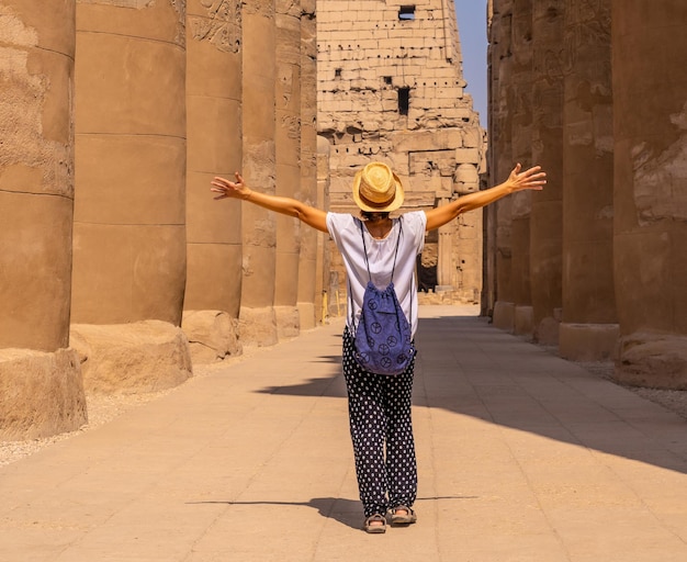 Foto turista che indossa un cappello in visita al tempio egizio di luxor in egitto