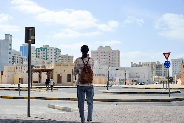 Sharjah UAE의 옛 지역에 있는 아랍 거리에 배낭을 메고 있는 여성 관광객