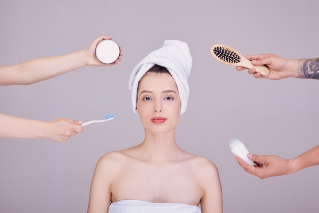 woman in a towel with hygiene items.