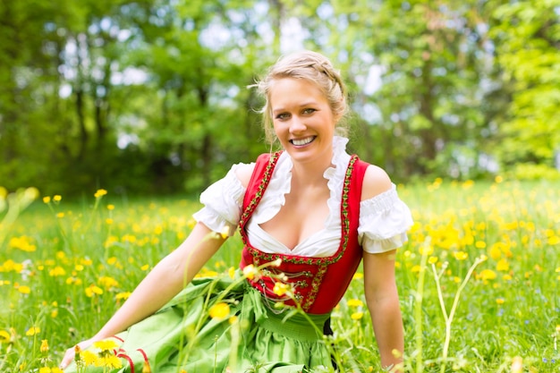 伝統的なバイエルンの服や牧草地のギャザースカートの女性