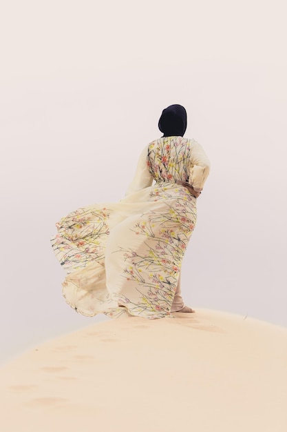 woman in traditional clothing standing on sand at beach
