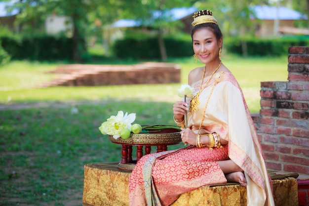 Woman in traditional dress fold lotus flower petal