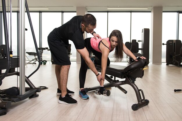 Woman Train Back On Bench With Personal Trainer