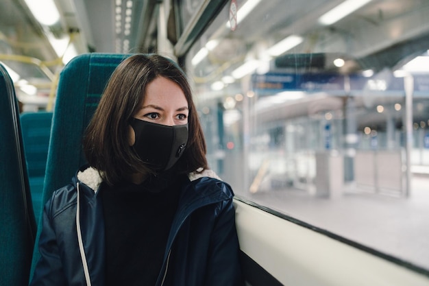 woman in a train wearing a face mask