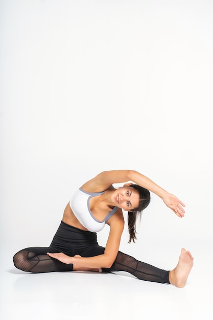 Allenatore donna facendo stretching prima di fare sport foto su sfondo bianco