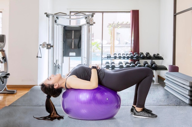Женщина тренирует мышцы живота в тренажерном зале