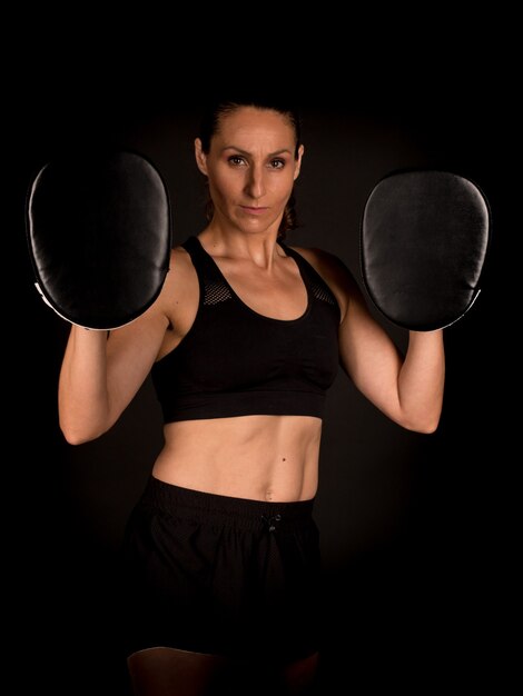 Woman training boxing with mittens