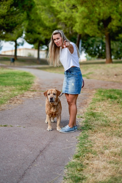 公園で犬を訓練する女性。