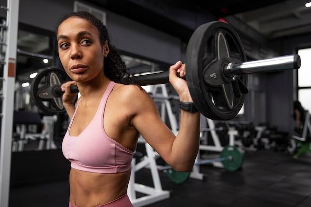 Foto allenamento donna per sollevamento pesi in palestra