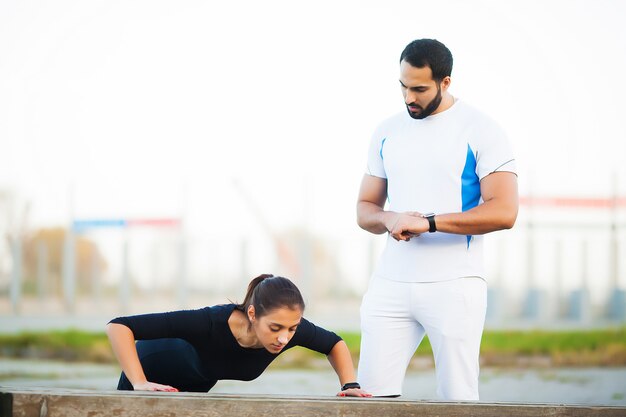 Addestramento della donna con personal trainer al parco