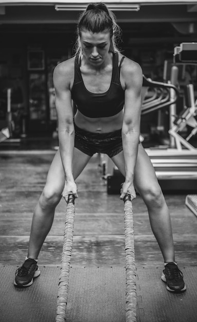 Foto donna che si allena con la corda in palestra.