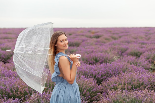 Woman under the transparent umbrella close up soft focus photo. Under the rain on lavender fields