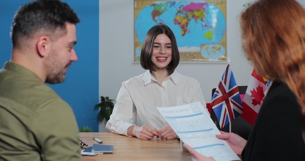 Woman travel agent giving visa application to young woman Traveler getting ready to travel on vacation Travelling concept