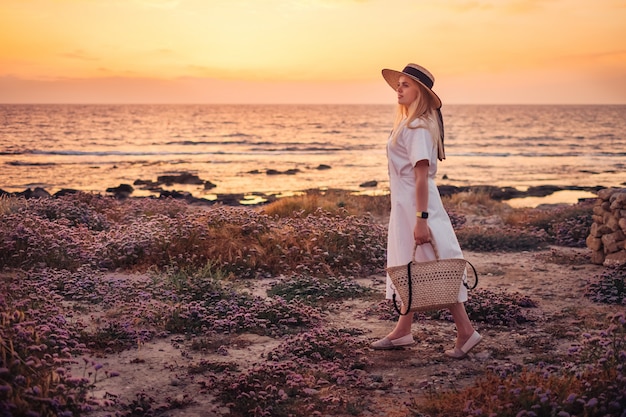 キプロスへの旅行と海の夕日を楽しむ女性