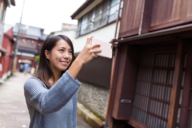 Woman travel in Kanazawa and taking photo by mobile phone