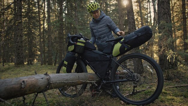 The woman travel on mixed terrain cycle touring with bike bikepacking The traveler journey with bicycle bags Magic forest park