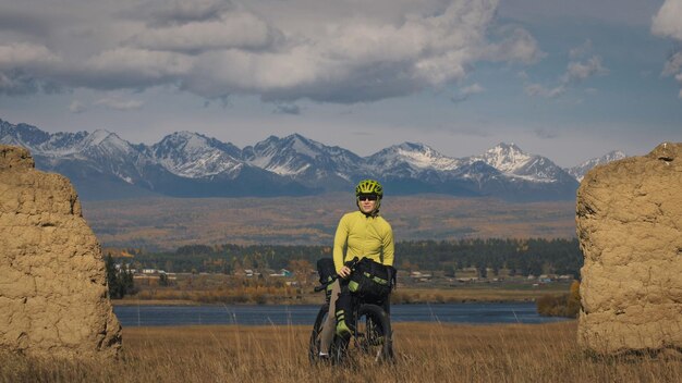 The woman travel on mixed terrain cycle touring with bikepacking. The traveler journey with bicycle bags. Sport tourism bikepacking.