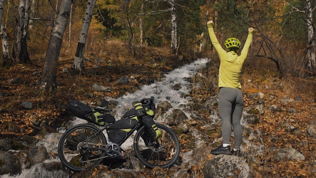 The woman travel on mixed terrain cycle touring with bikepacking. The traveler journey with bicycle bags. Sport tourism bikepacking.