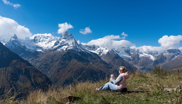 Viaggiatore donna beve caffè con vista sul paesaggio montano