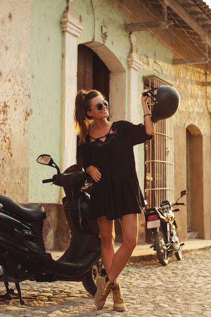 Woman traveler driving scooter by the old city streets