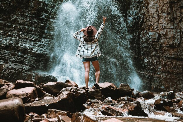 Woman traveler enjoying view of waterfall copy space