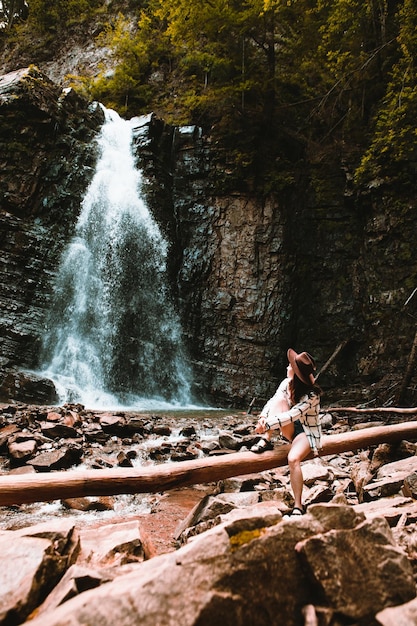 滝の景色を楽しむ女性旅行者