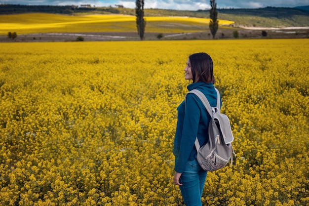 Photo woman traveler in a flowering rapeseed field