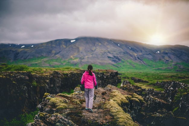 Woman traveler hiking across Iceland landscape.