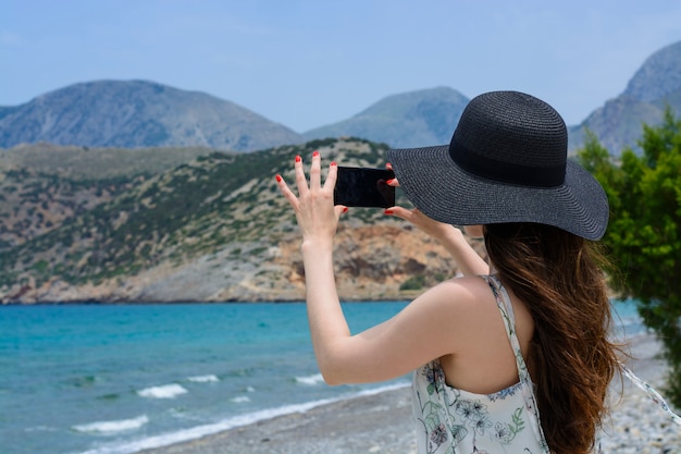 Женщина путешественник делает себе на заднем плане красивый естественный вид горы на острове. Концепция - туризм, путешествия фото из отпуска.