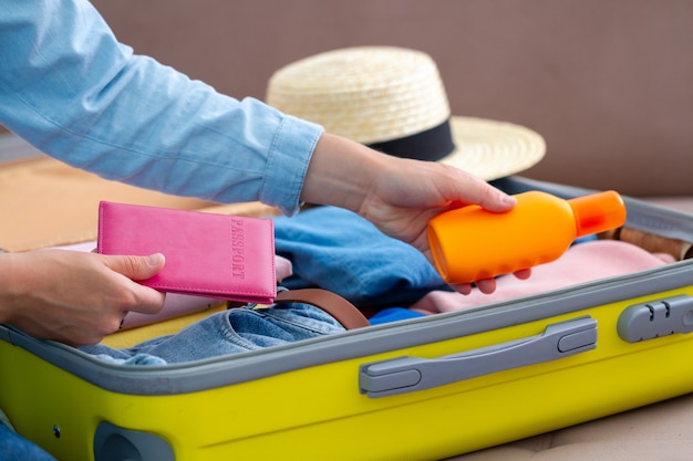 Il viaggiatore della donna imballa i bagagli a casa per un nuovo viaggio. valigia da viaggio per le vacanze