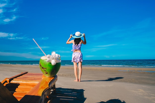 woman traveler in sexy swimming suit standing on the beach and enjoying 