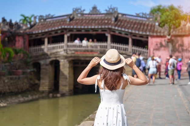 사진 호이안(hoi an) 고대 도시 베트남의 랜드마크이자 관광 명소인 베트남과 동남아시아 여행 컨셉에 인기 있는 일본 덮힌 다리 또는 카우 사원에서 관광하는 여성 여행자