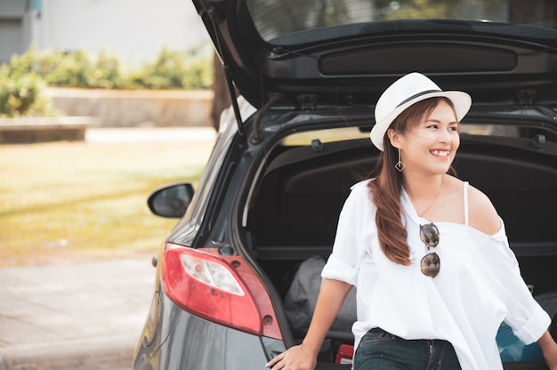 Viaggiatore della donna che si siede sull'autovettura a tre oa cinque porte dell'automobile